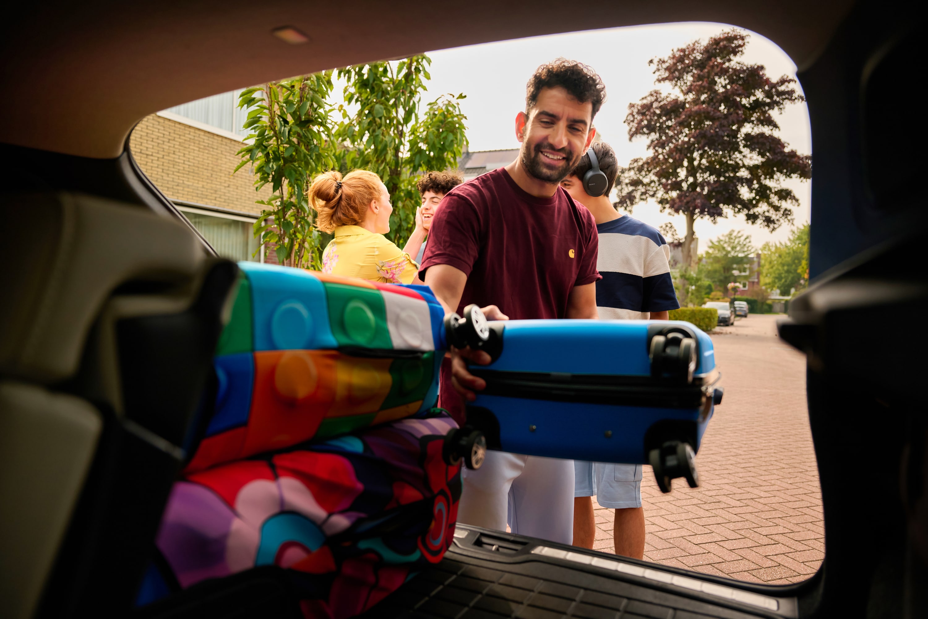 Man zet koffer in de auto voor de vakantie