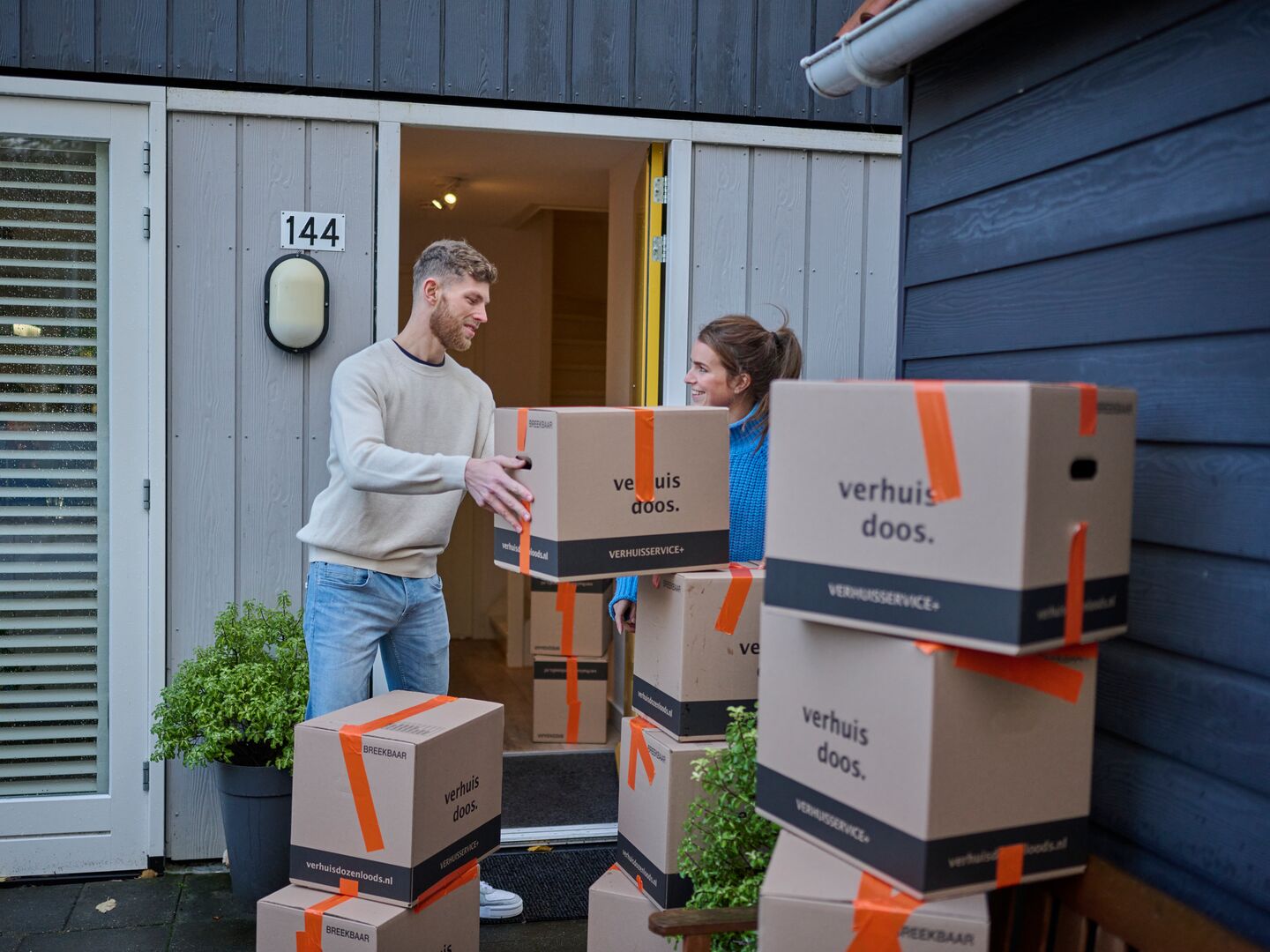 Young couple moving out and lifting moving boxes