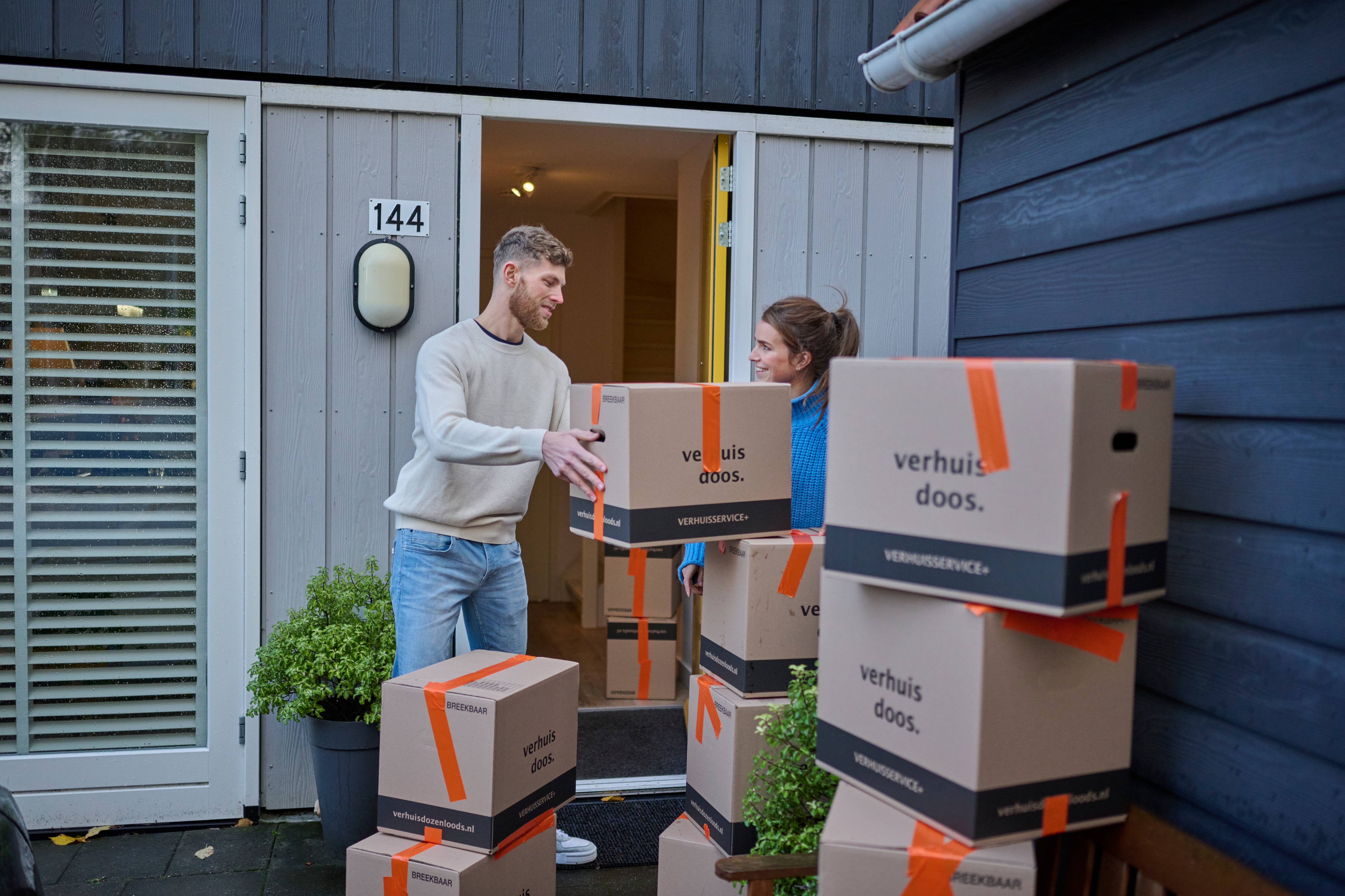 Young couple moving out and lifting moving boxes