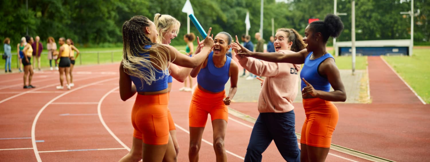 4 vrouwen juichen op een running track