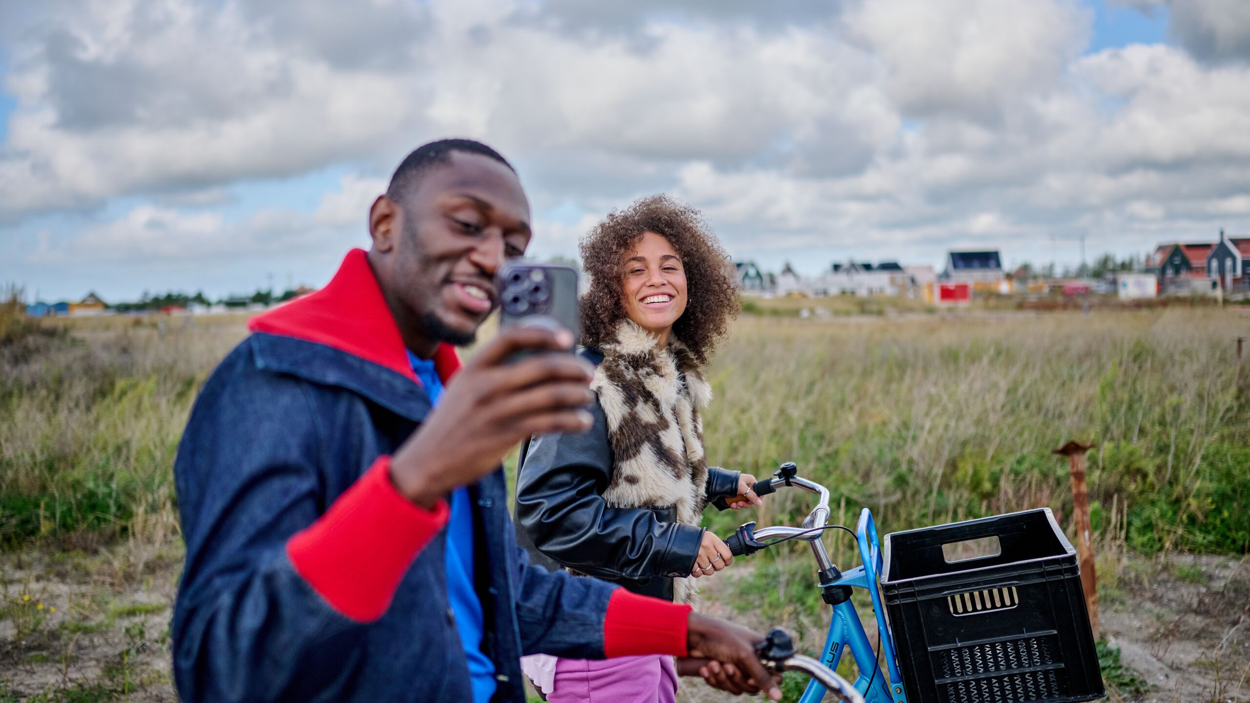happy young couple on a bike with a phone in hand