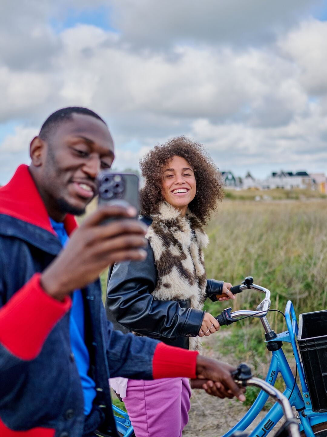 happy young couple on a bike with a phone in hand