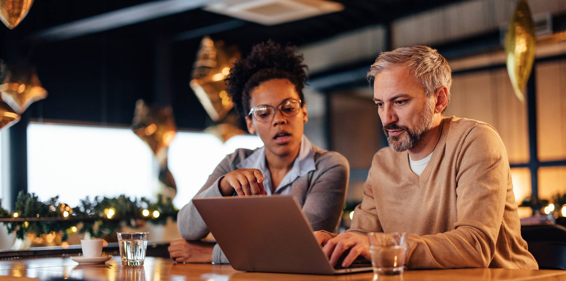 Een man en vrouw werken samen achter een laptop