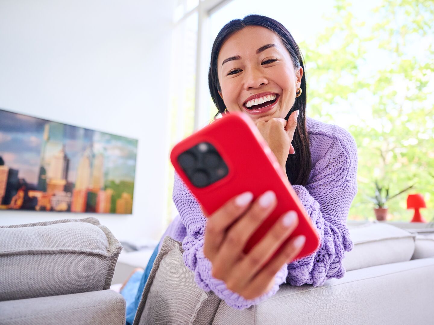 Meisje in huis met Iphone (lachend)