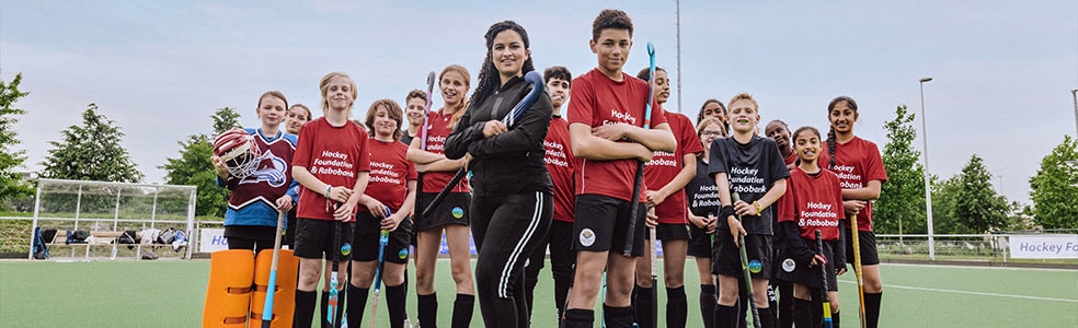 Hockeyleden in rode shirts in een groepsformatie
