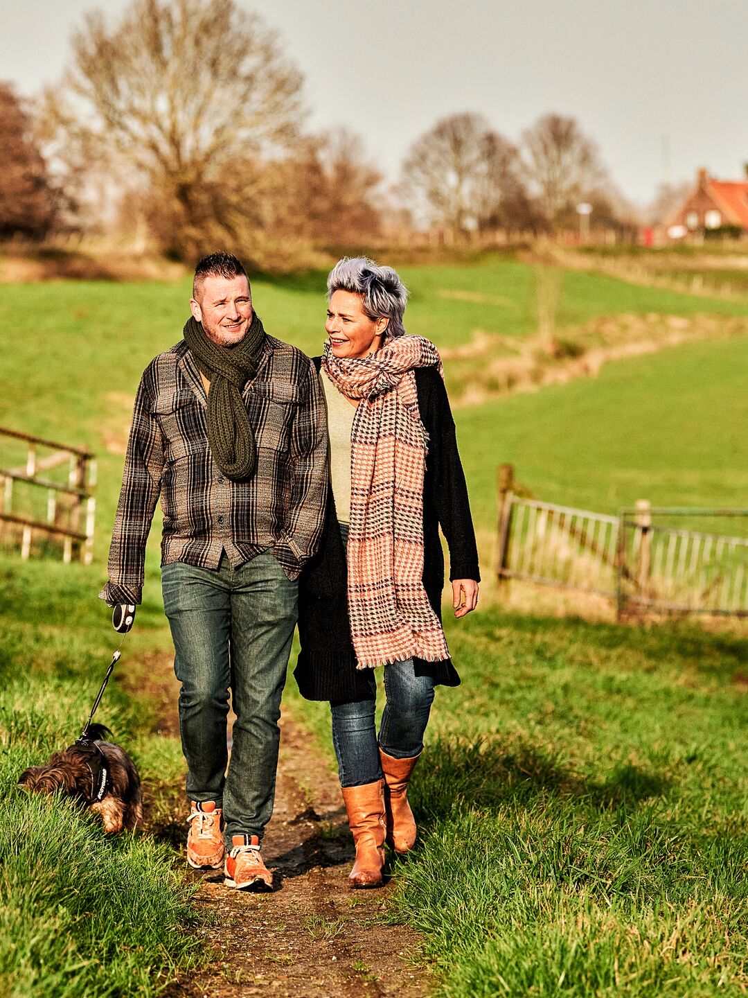 Man en vrouw genieten van een herfstwandeling met hun hondje