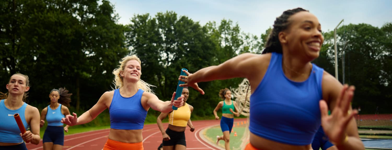 Vrouwen geven een stokje over in een estafette race