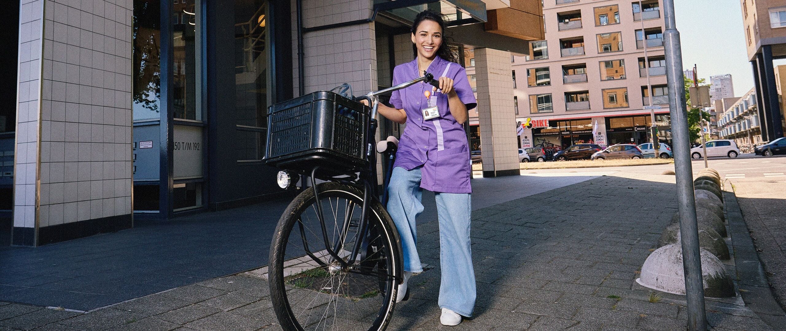 Persoon lachend met een fiets in de hand