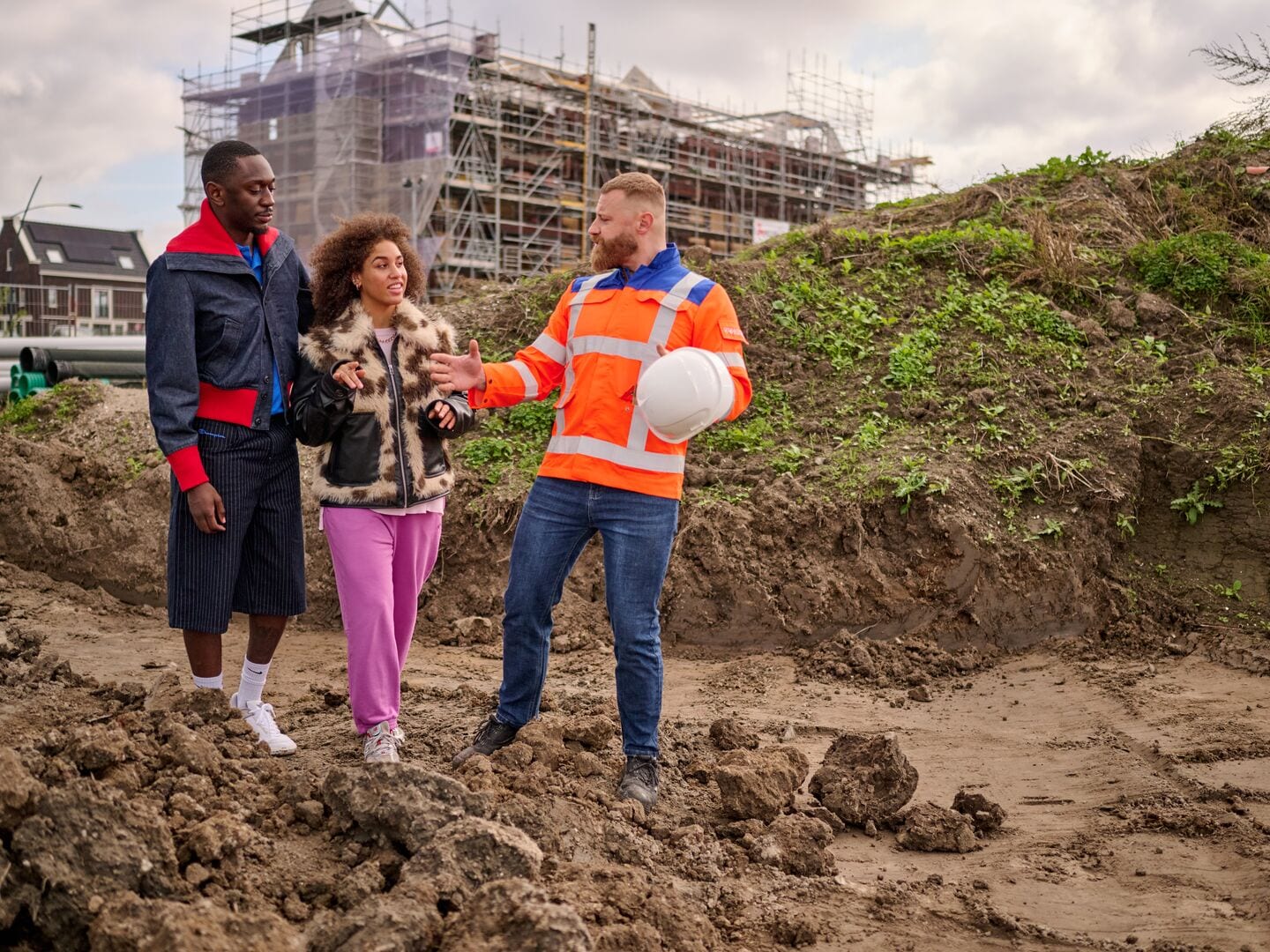 couple looking with the contractor at the grounds to place their new house