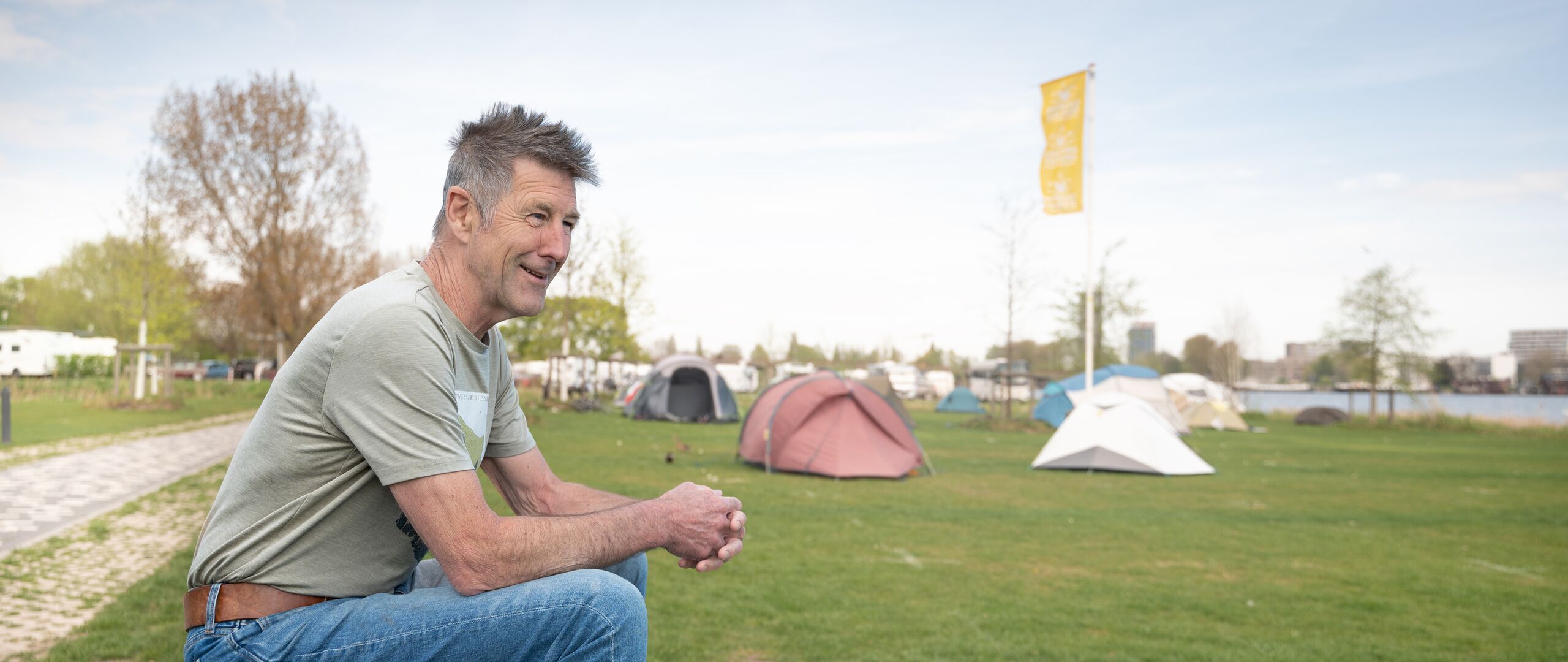 Man zit op een grasveld naast tenten