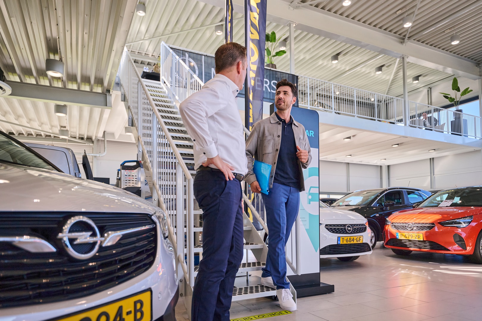 2 mannen aan het praten in auto showroom