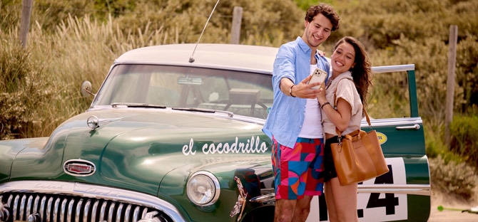 man en vrouw poseren voor een oldtimer