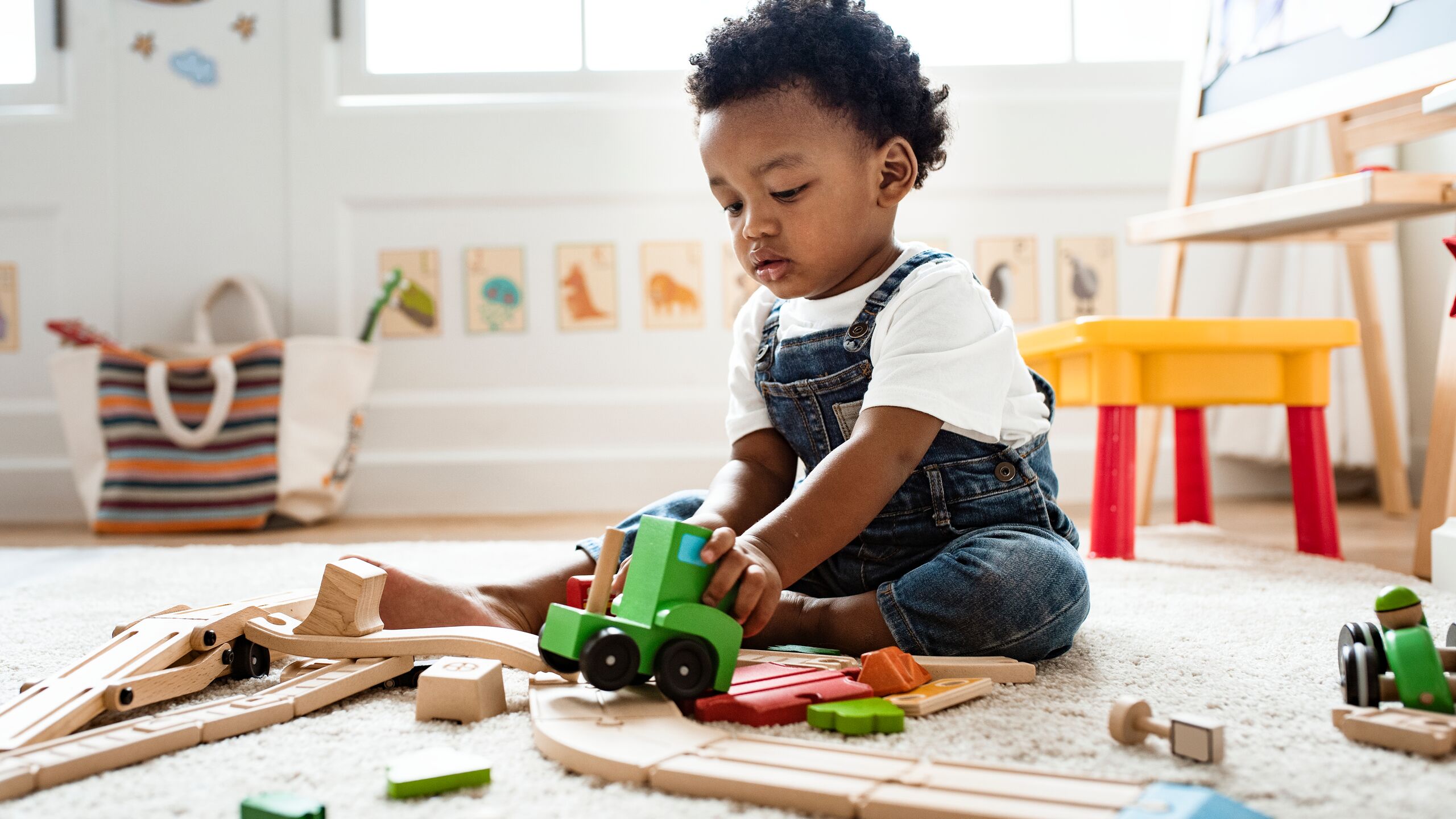 Cute little boy playing with a toy train